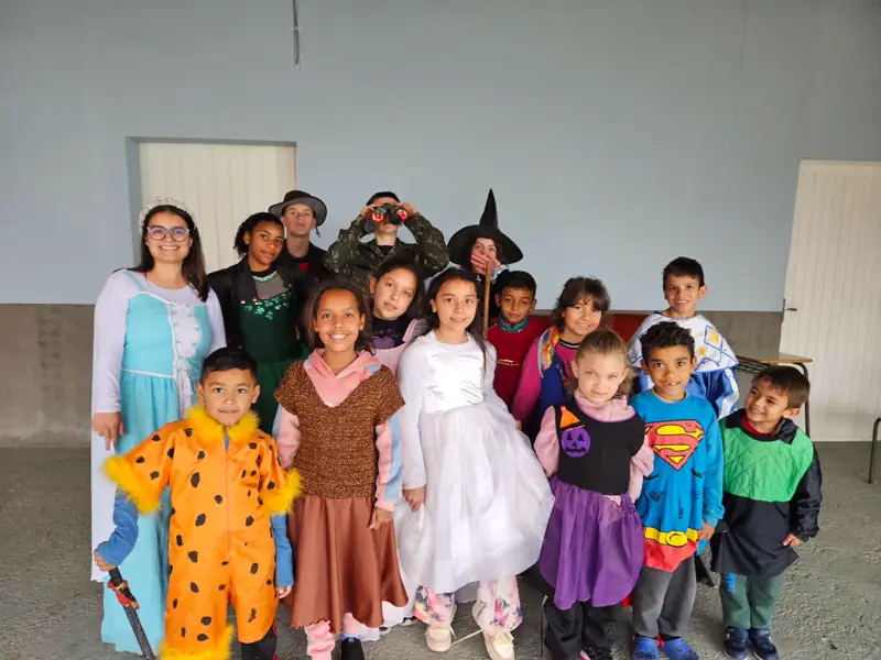 Crianças fantasiadas posando em grupo numa festa da ACRICA