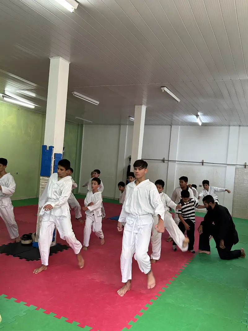 Crianças de quimono numa aula de taekwondo