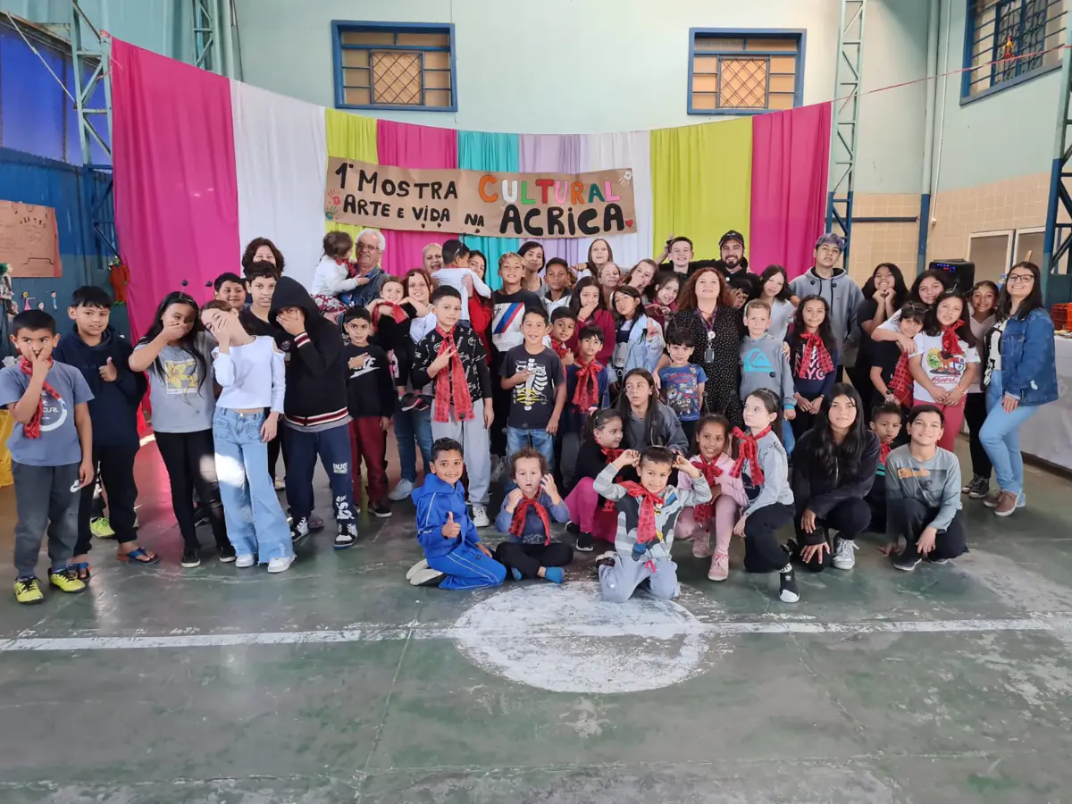 Grande grupo de crianças e adolescentes posando juntos na Mostra Cultural da ACRICA